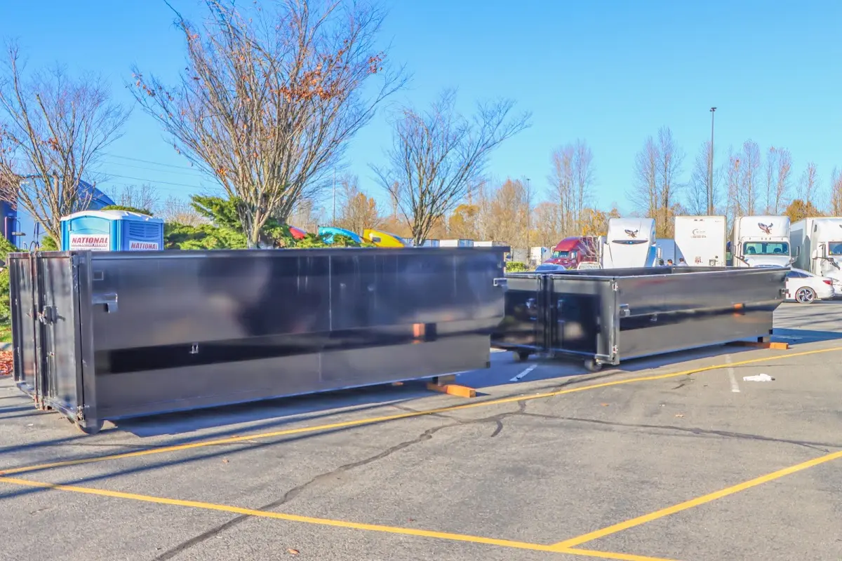 Professional dumpster rental service with roll-off container on residential driveway in Muskegon Heights